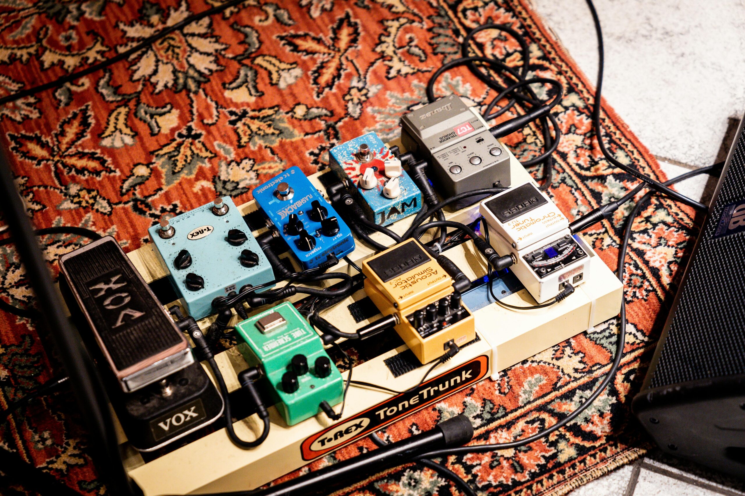 Blog A vibrant display of guitar pedals on a patterned rug, highlighting music technology.